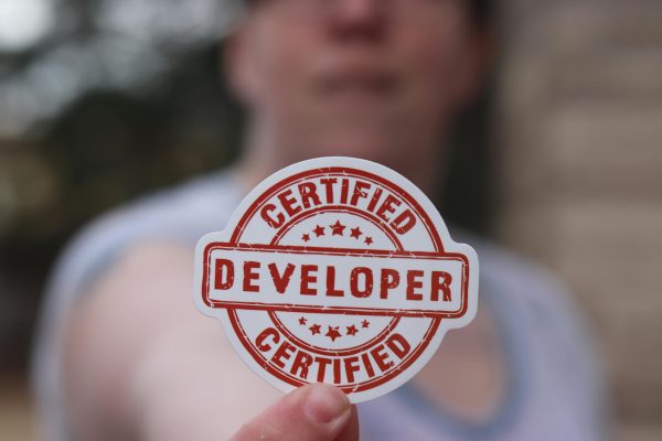 Close-up of a certified developer badge being held outdoors.